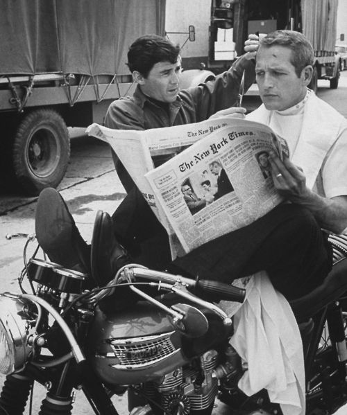 Paul Newman lit le journal The New York Times sur une moto Triumph