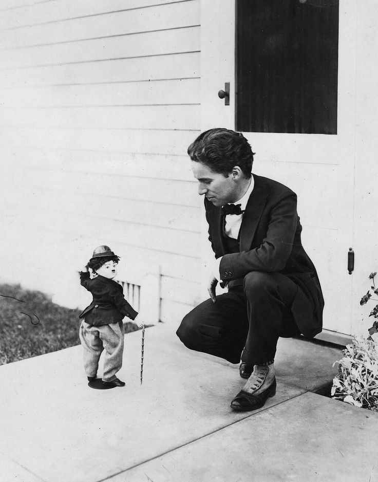 Charlie Chaplin devant un jouet à son effigie