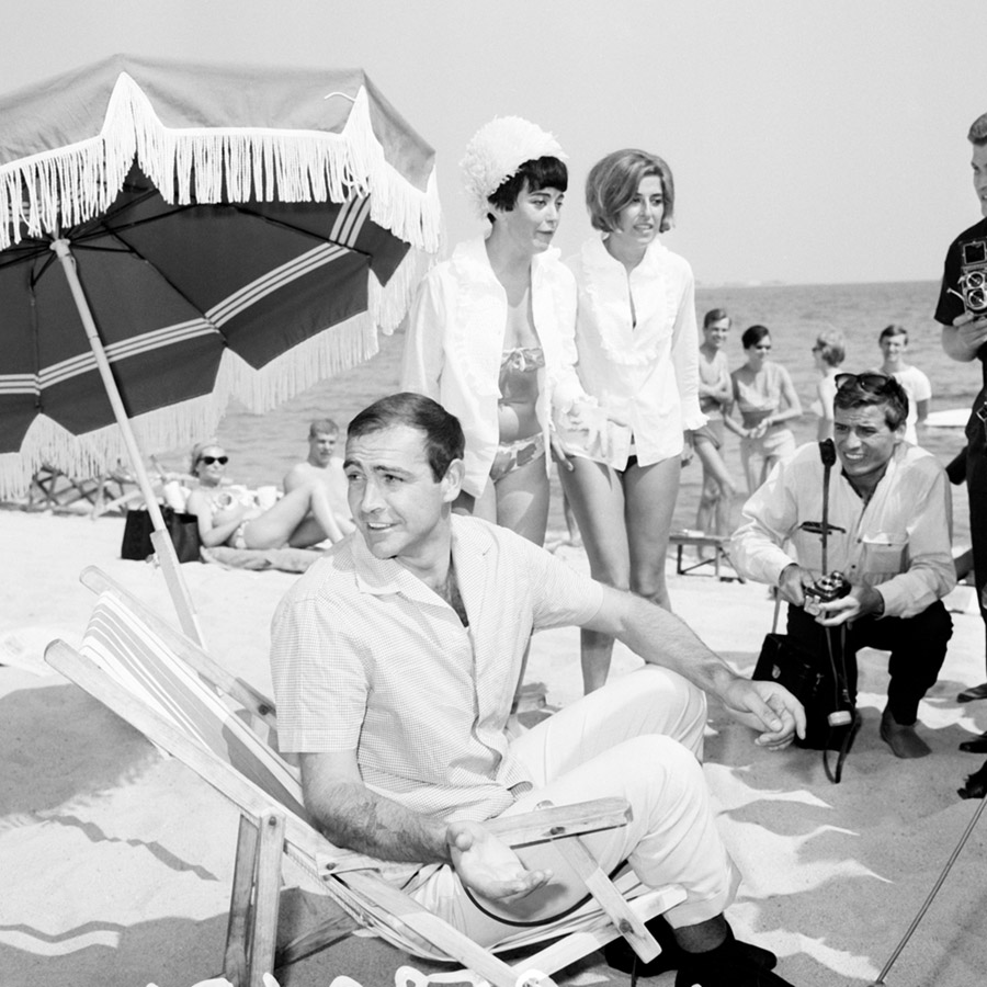Sean Connery sur la plage entouré de femmes et de photographes © Photo sous Copyright
