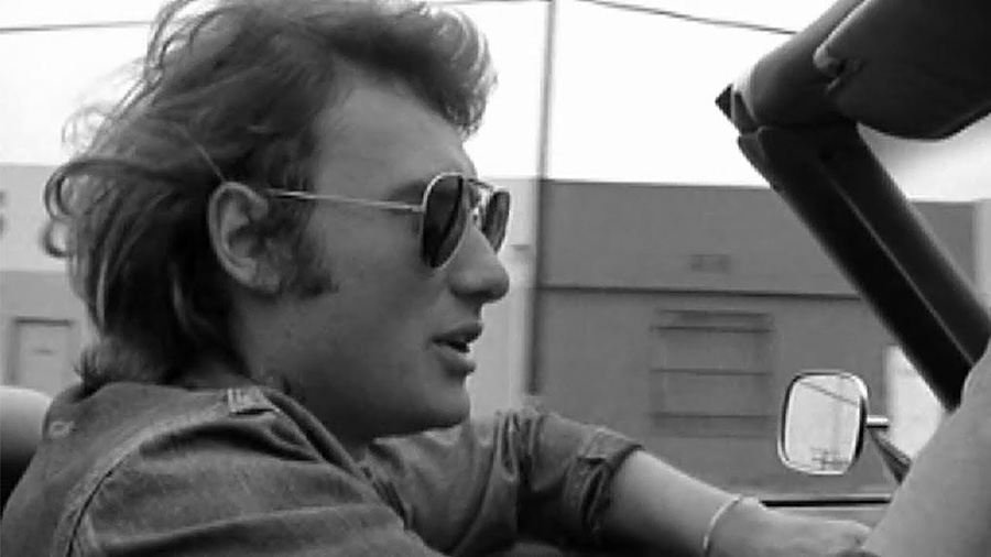Johnny Hallyday en voiture et en lunette Ray-Ban © Copyright : DR
