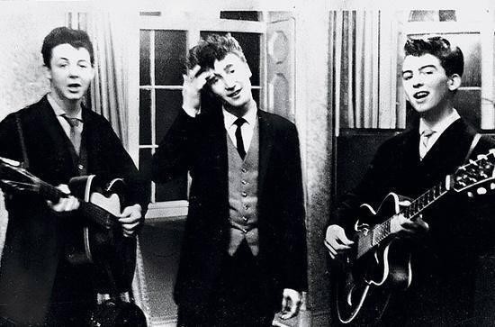 Paul McCartney, John Lennon et George Harrisson jouant de la guitare à une réception de mariage en 1958